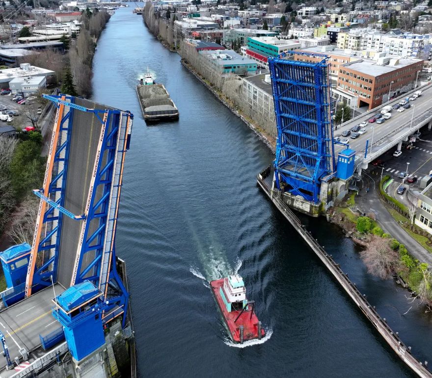 A Ship Canal drawbridge seen from above, with a gravel barge passing through.